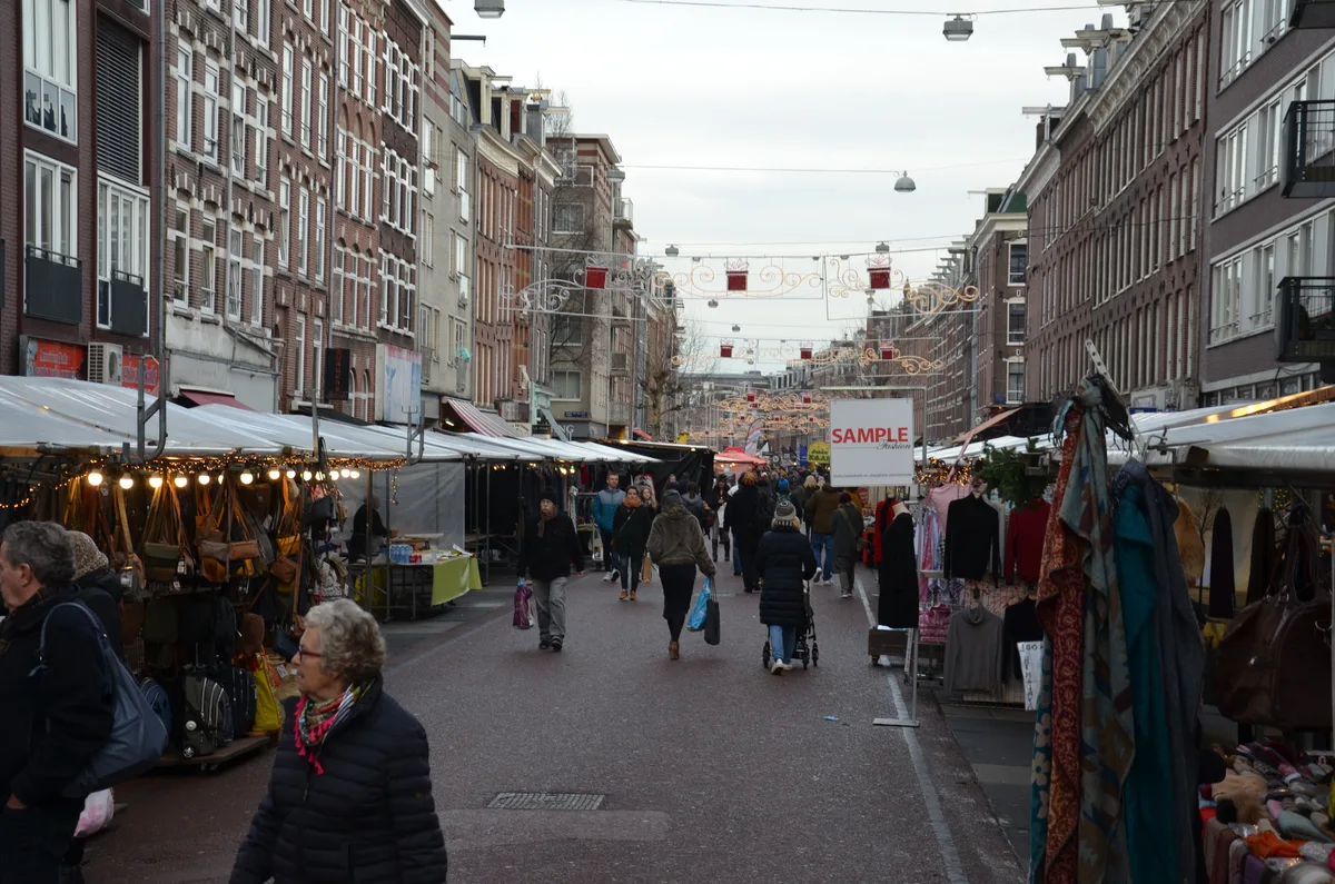 De Albert Cuypmarkt in De Pijp Amsterdam met honderden kramen langs de volle straat op een drukke marktdag