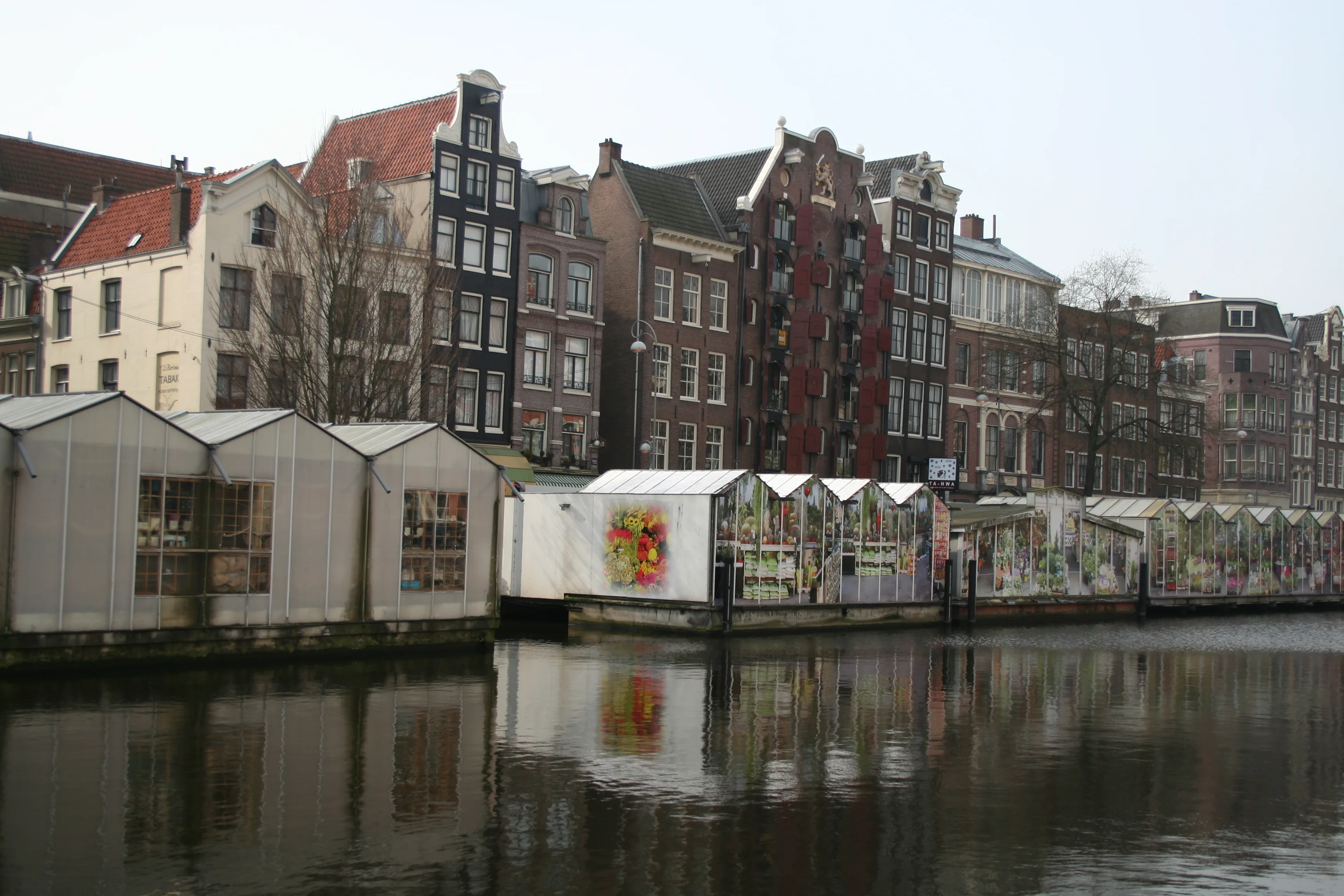 De Bloemenmarkt op het Singel in Amsterdam met kleurrijke bloemen, bollen en souvenirs op drijvende ponton-kraampjes