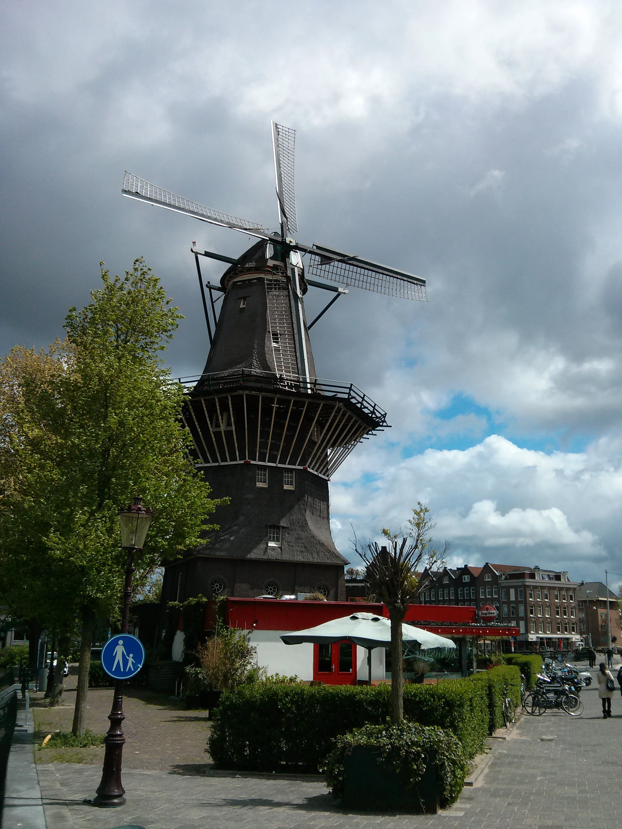De windmolen De Gooyer in Amsterdam-Oost met het bruine café van Brouwerij 't IJ ervoor en biertonnen op de kade