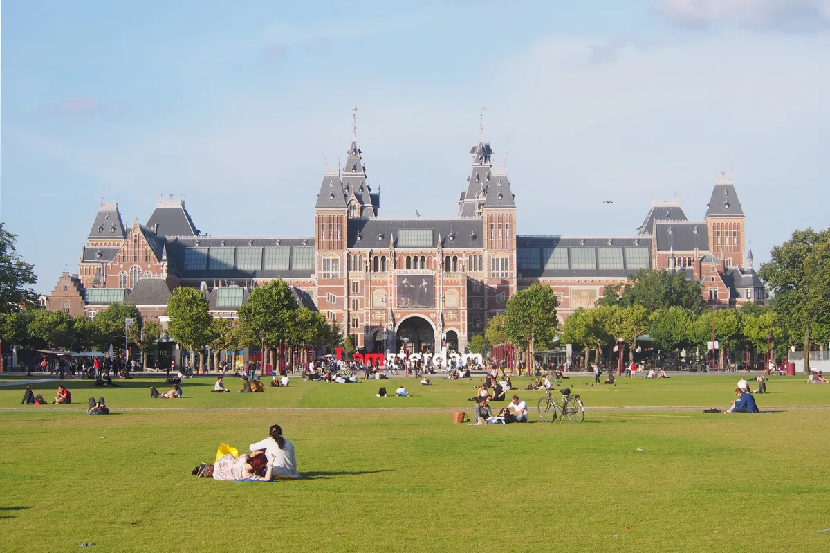 Uitzicht op het Rijksmuseum vanaf het Museumplein in Amsterdam met het grote grasveld op de voorgrond